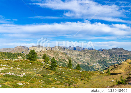Alpine landscape with green mountain valley and distant peaks 132948465