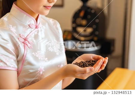 焙煎されたコーヒー豆を持つチャイナドレスを着た女性 132948513