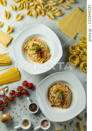 Italian spaghetti bolognese plates with raw pasta varieties Italian spaghetti bolognese plates with raw pasta varieties 132948585