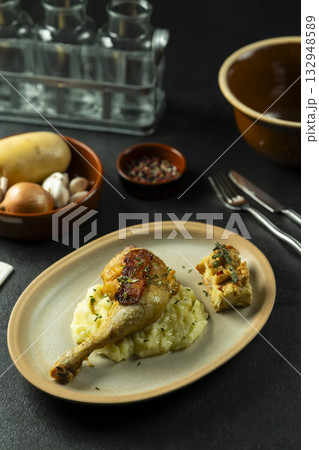 Roasted chicken leg served with mashed potatoes and cornbread 132948589