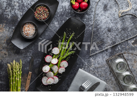 Asparagus and radish salad with spices on black plate 132948599