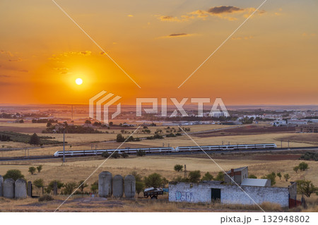 High speed train traveling Alcazar de San Juan at sunset 132948802