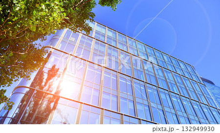 Modern luxury office building.The structure features a glass and concrete walls, showcasing contemporary architecture. The green surroundings of office buildings. Trees and shrubs in the city. 132949930