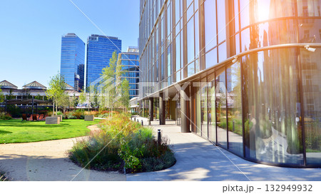 Modern luxury office building.The structure features a glass and concrete walls, showcasing contemporary architecture. The green surroundings of office buildings. Trees and shrubs in the city. 132949932