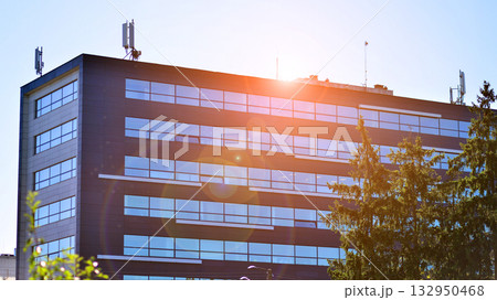 Modern luxury office building.The structure features a glass and concrete walls, showcasing contemporary architecture. The green surroundings of office buildings. Trees and shrubs in the city. Modern luxury office building.The structure features a glass and concrete walls, showcasing contemporary architecture. The green surroundings of office buildings. Trees and shrubs in the city. 132950468