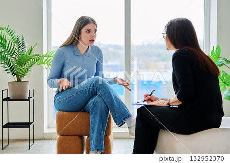 Young woman in a therapy session talking with a psychotherapist 132952370