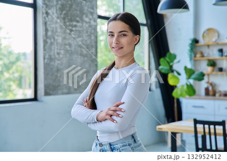 Portrait of confident successful teenage girl posing with crossed arms at home 132952412