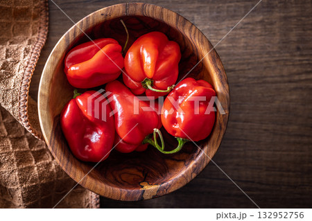 Red chili pepper habanero in bowl on wooden table. Top view. Red chili pepper habanero in bowl on wooden table. Top view. 132952756