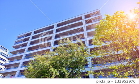 European residential architecture harmonizing with nature. Eco-friendly living in city with greens. Eco apartment building saving energy and fresh air concept.  132952970