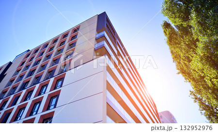 European residential architecture harmonizing with nature. Eco-friendly living in city with greens. Eco apartment building saving energy and fresh air concept.  132952976