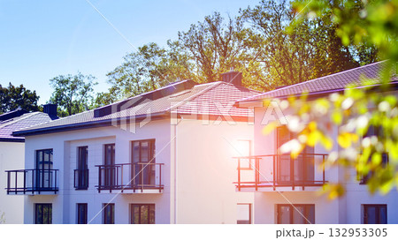 New single family houses in a new development area. Residential homes with modern facade. Terraced family homes in newly developed housing estate. The real estate market in the suburbs.  132953305