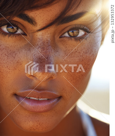Close-up of a woman with striking freckles and warm brown eyes enjoying sunlight outdoors Close-up of a woman with striking freckles and warm brown eyes enjoying sunlight outdoors 132953372