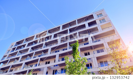 European residential architecture harmonizing with nature. Eco-friendly living in city with greens. Eco apartment building saving energy and fresh air concept.  132953742