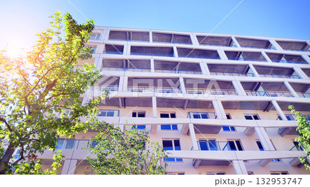 European residential architecture harmonizing with nature. Eco-friendly living in city with greens. Eco apartment building saving energy and fresh air concept.  132953747