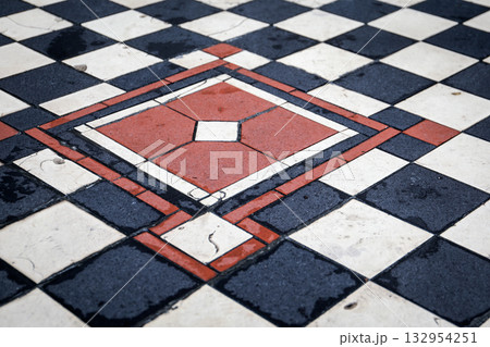 Decorative geometric floor tiles in red, black and white colors, creating a vintage symmetrical Decorative geometric floor tiles in red, black and white colors, creating a vintage symmetrical 132954251
