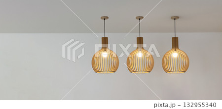 Bamboo ceiling lamp hanging on white ceiling indoors Bamboo ceiling lamp hanging on white ceiling indoors 132955340