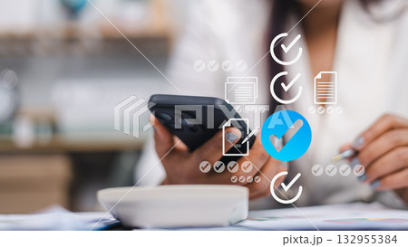 Businesswoman Using Smartphone for Digital Task Management and Checklist App 132955384