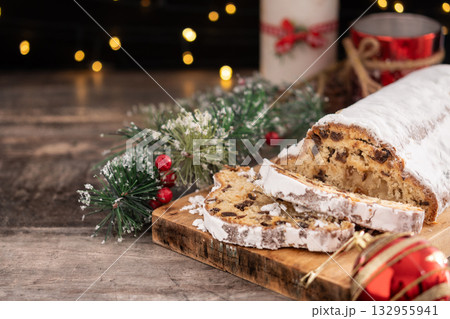 Traditional Christmas Stollen with Raisins and Powdered Sugar on christmas atmosphere background Traditional Christmas Stollen with Raisins and Powdered Sugar on christmas atmosphere background 132955941