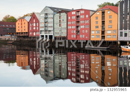 Brightly painted wooden houses on stilts line the Trondheim harbor Brightly painted wooden houses on stilts line the Trondheim harbor 132955965