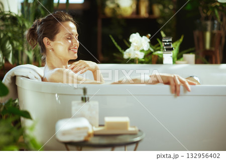 Woman\'s Blissful Spa Moment in Freestanding Tub Woman\'s Blissful Spa Moment in Freestanding Tub 132956402