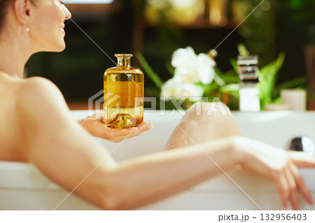 Woman Relaxing in Bathtub with Bath Oil Woman Relaxing in Bathtub with Bath Oil 132956403