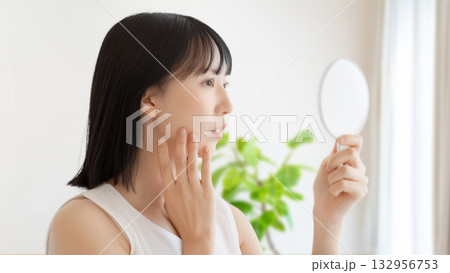 鏡で肌をチェックする女性 鏡で肌をチェックする女性 132956753