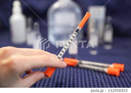 Woman holds insulin syringe medical background blurred 132956855