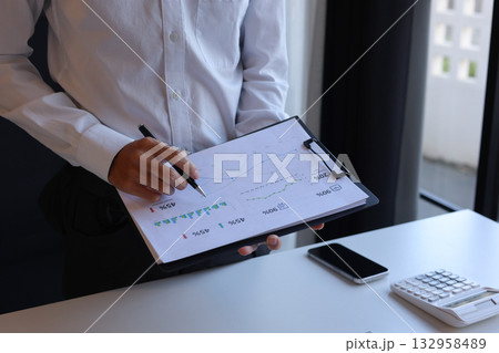 Businessman working in office reading documents analyze data for project planning. 132958489