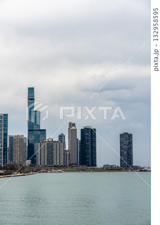 Chicago skyline view with skyscrapers and Lake Michigan under a cloudy sky 132958595