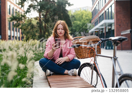 Beautiful curvy woman relaxing in public park, holding phone. Beautiful curvy woman relaxing in public park, holding phone. 132958805