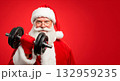Santa Claus working out with a dumbbell on a vibrant red background 132959235