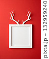White antlers peeking over a white frame against a vibrant red background 132959240