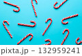 Festive candy canes scattered on a vibrant blue background 132959241