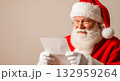 Santa Claus reading a letter with a smile, Christmas holiday concept 132959264
