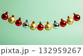 Festive Christmas ornaments strung on a thin wire against a soft green background 132959267