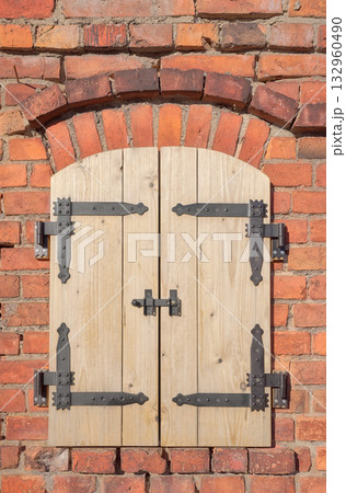 Old brick wall with new wooden shutters. Old brick wall with new wooden shutters. 132960490