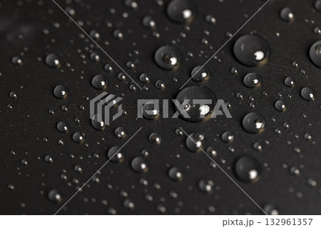 a surface covered with water droplets, details of the wet part of an object made of black plastic a surface covered with water droplets, details of the wet part of an object made of black plastic 132961357