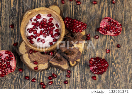 delicious fresh pink yogurt and ripe red pomegranate seeds, delicious pomegranate yogurt and fresh ripe red pomegranate 132961371