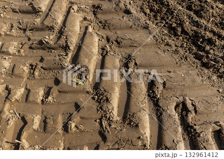 traces of a tractor on the soil of a field during tillage, soil with traces of passing heavy agricultural machinery after tillage traces of a tractor on the soil of a field during tillage, soil with traces of passing heavy agricultural machinery after tillage 132961412