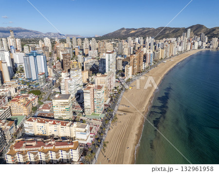 Aerial view of Benidorm, Spain, showcasing high-rise buildings and the Mediterranean Sea in the background. 132961958