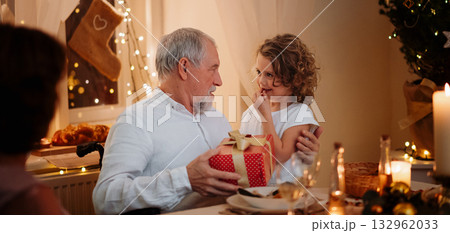Grandfather spending Christmas Eve with small granddaughter. Grandfather spending Christmas Eve with small granddaughter. 132962033