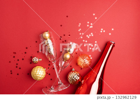 Red Holiday Celebration with Champagne Flutes, Bottle, and Ornaments Red Holiday Celebration with Champagne Flutes, Bottle, and Ornaments 132962129
