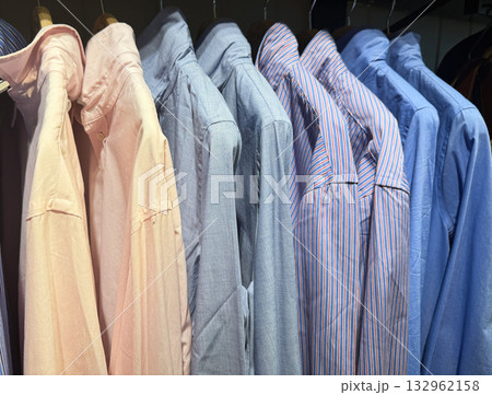Unisex shirts hanging neatly on clothing rack Unisex shirts hanging neatly on clothing rack 132962158