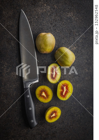 Red kiwi fruit on black table. Top view. Red kiwi fruit on black table. Top view. 132962548