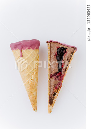 Whole and sliced berry chocolate ice cream cone on white background, minimalist food concept Whole and sliced berry chocolate ice cream cone on white background, minimalist food concept 132963421