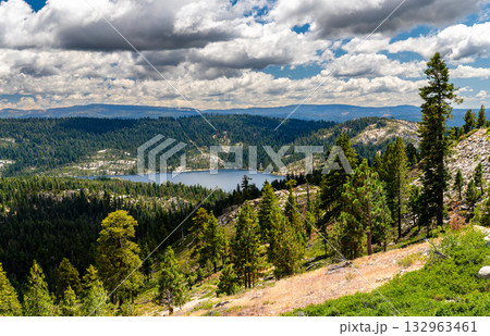 Scenic view of Bear River Reservoir from Peddler Hill Overlook in the Sierra Nevada mountains, California. Pine forests cover the hills under a dramatic cloudy sky. Represents nature and wilderness 132963461