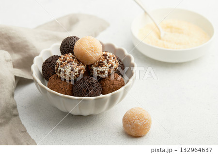 Typical Brazilian sweet brigadeiro. A heap of assorted flavors of candies on a white table Typical Brazilian sweet brigadeiro. A heap of assorted flavors of candies on a white table 132964637