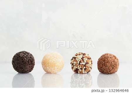 Typical Brazilian sweet brigadeiro. Line of candies with different tastes on a marble background 132964646