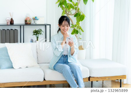 部屋でスマホを操作する若い女性 部屋でスマホを操作する若い女性 132965899