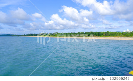 Turquoise Ocean Water Surface with Coastal View of Sandy Shoreline and Dense Tropical Greenery Turquoise Ocean Water Surface with Coastal View of Sandy Shoreline and Dense Tropical Greenery 132966245
